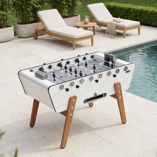 Baby-foot de luxe pour extérieur Stella Champion Outdoor blanc installé sur une terrasse, structure en HPL et pieds en bois Moabi pour une expérience de jeu haut de gamme en plein air.