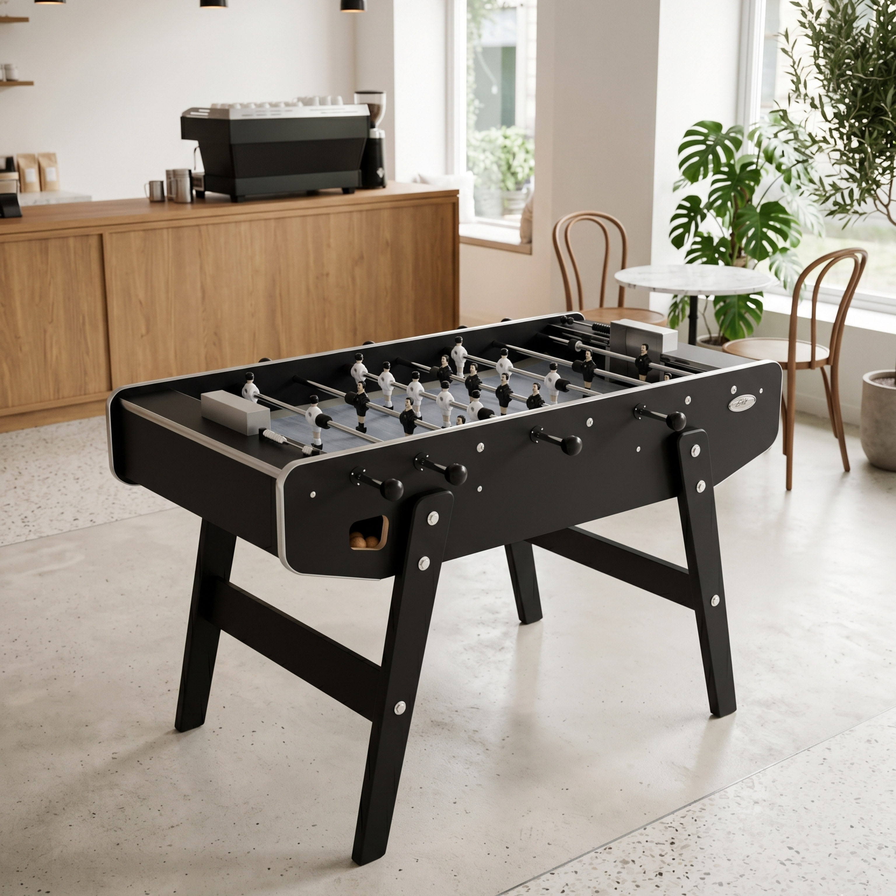 Baby-foot Stella Club noir installé dans un salon chaleureux, le modèle traditionnel inspiré des estaminets pour retrouver l'ambiance authentique du jeu de bar dans un intérieur convivial.
