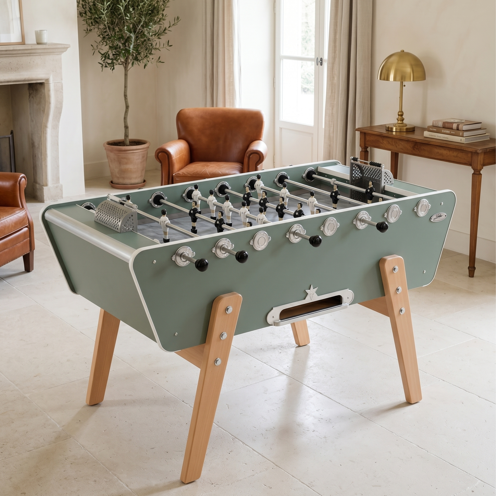 Baby-foot Stella Champion Collector vert eucalyptus installé dans un salon moderne, fusion contemporaine et rétro avec pieds en hêtre vernis pour une décoration intérieure tendance.