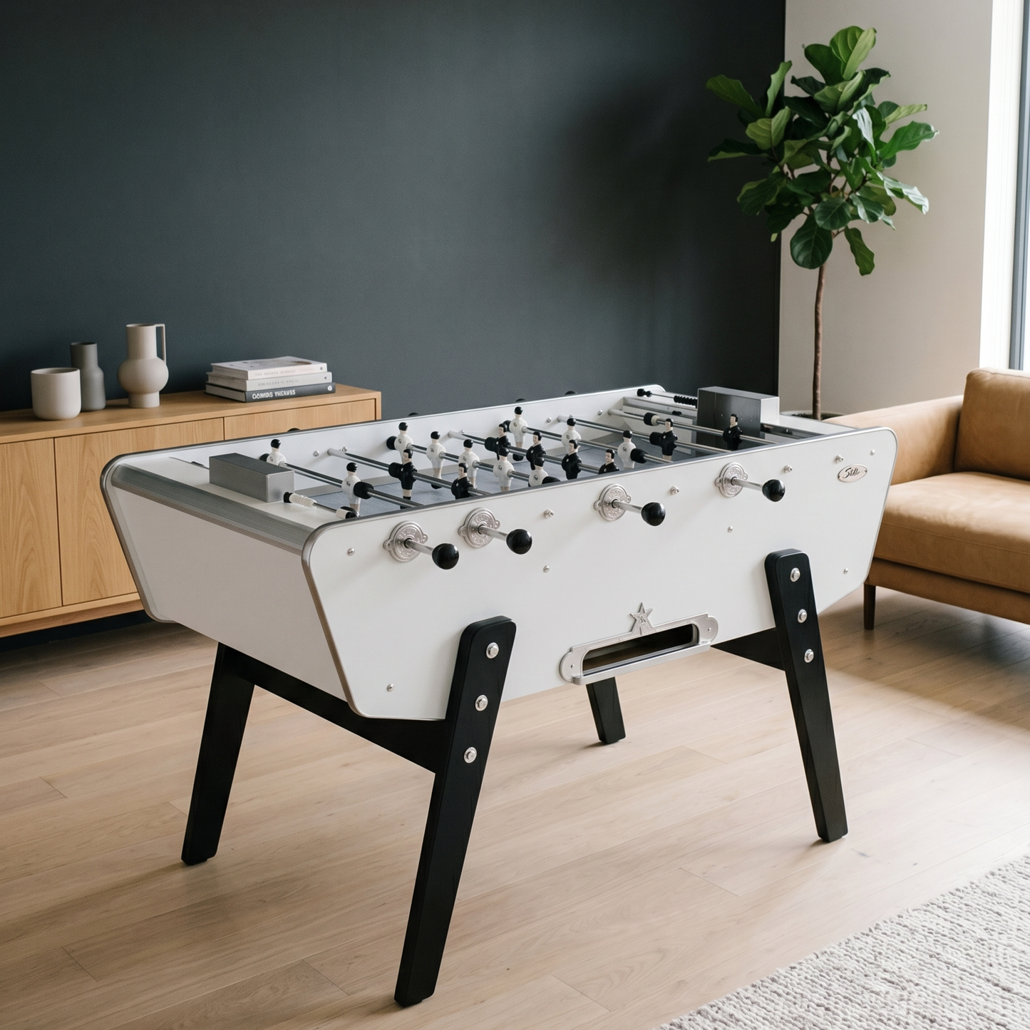 Baby-foot Stella Star blanc installé dans un salon épuré, modèle emblématique au design contemporain avec caisse style bateau et pieds en hêtre massif pour une décoration intérieure lumineuse.