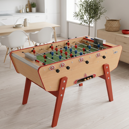 Baby-foot Stella Star finition hêtre naturel installé dans un salon chaleureux, design authentique et convivial en bois massif pour une décoration intérieure chaleureuse et intemporelle.