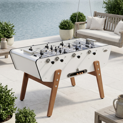 Baby-foot d'extérieur Stella Star Outdoor blanc installé sur une terrasse, design épuré et lumineux alliant élégance et robustesse pour le jeu en plein air.

