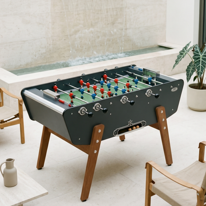 Baby-foot d'extérieur Stella Star Outdoor gris anthracite installé sur une terrasse, coloris contemporain et élégant pour un espace extérieur moderne et convivial.