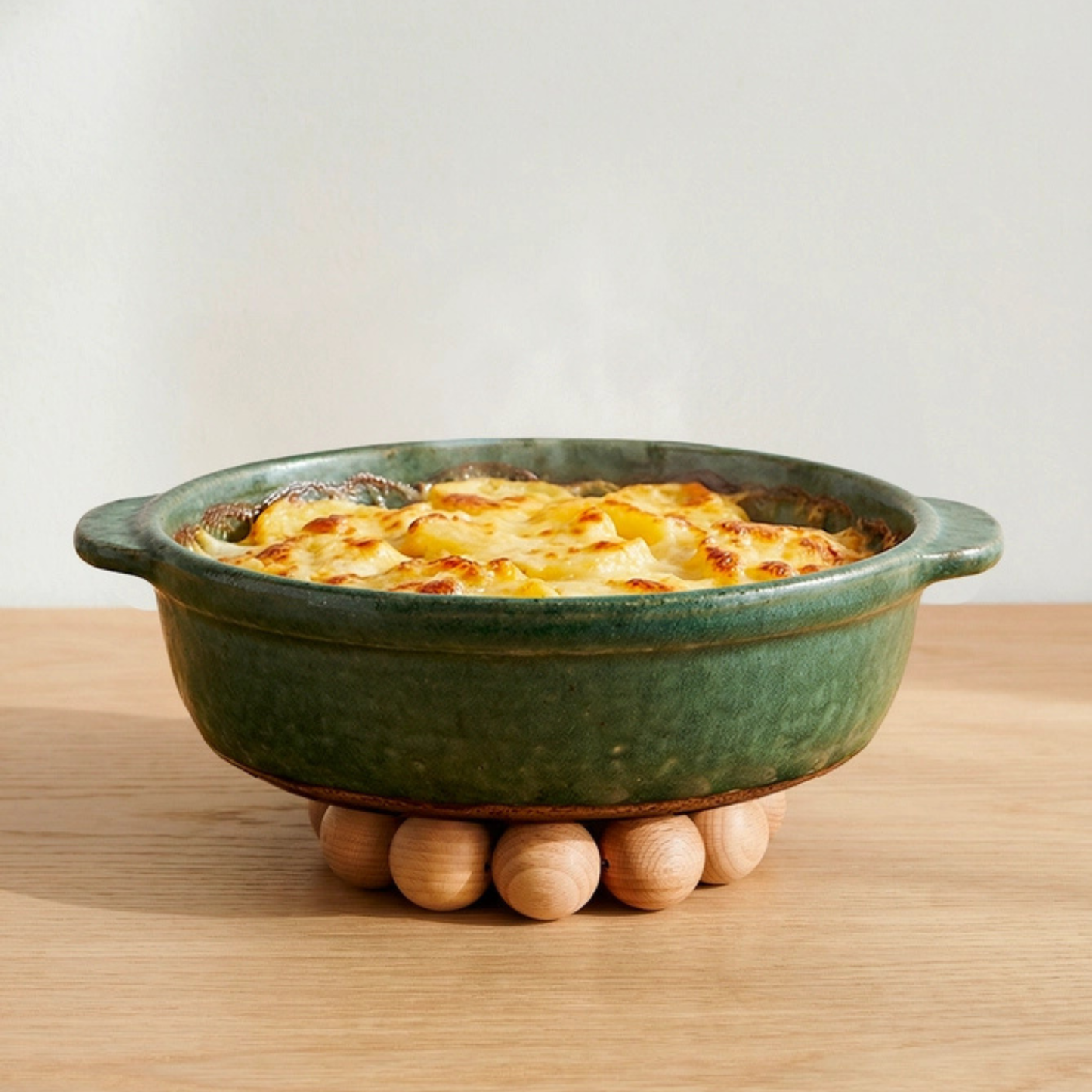 Dessous de plat graphique en bois supportant un plat chaud pour protéger une table de salle à manger.