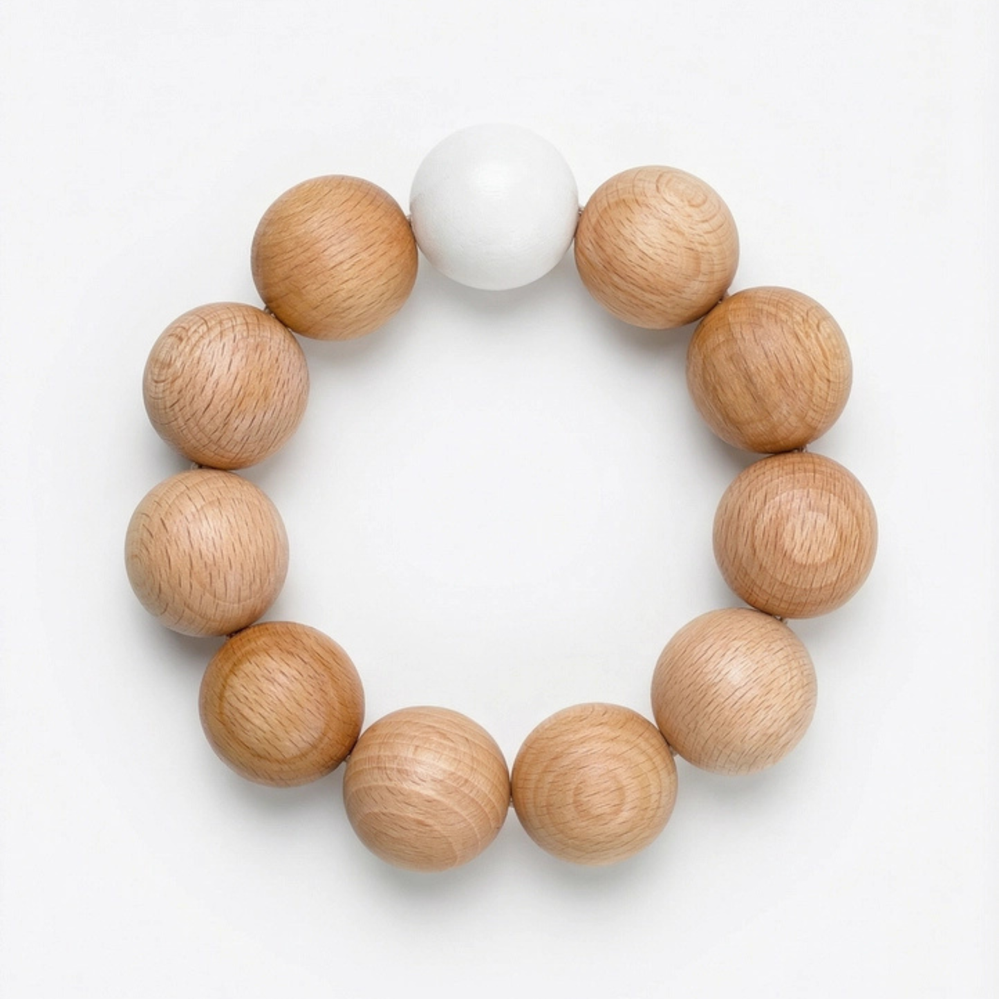 Dessous de plat Nid par Reine Mère en billes de bois de hêtre naturel, format circulaire sur fond blanc épuré.