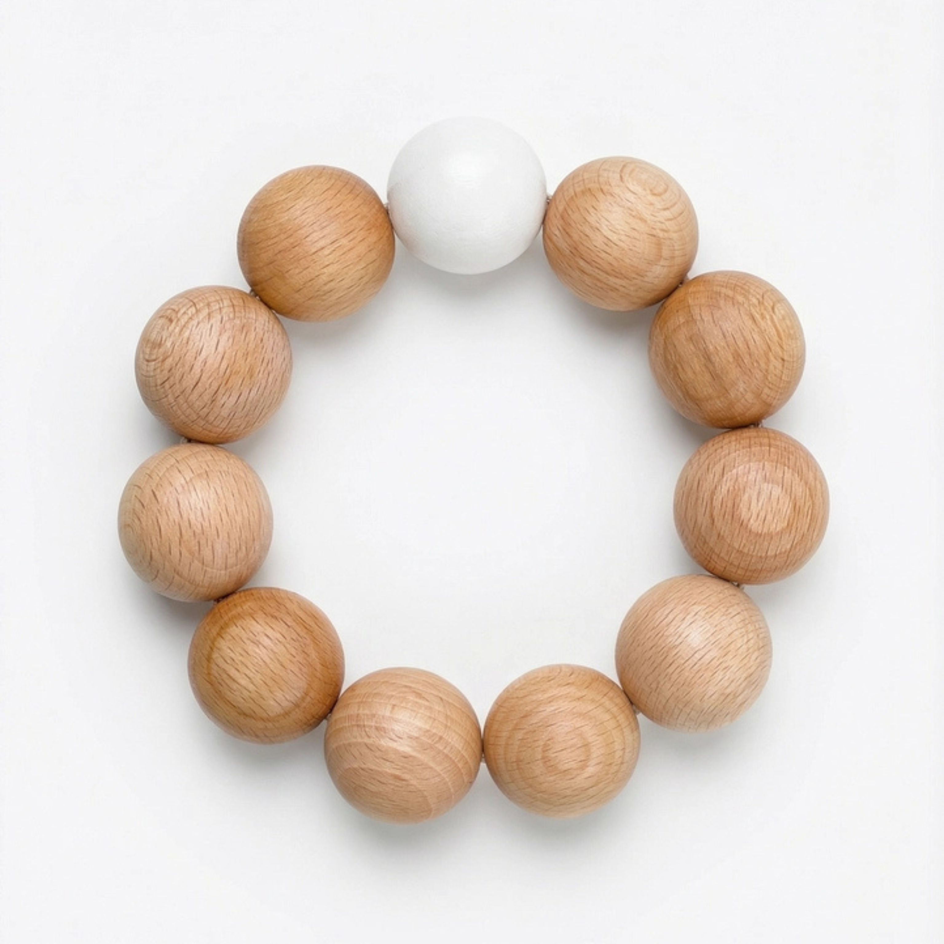 Dessous de plat Nid par Reine Mère en billes de bois de hêtre naturel, format circulaire sur fond blanc épuré.