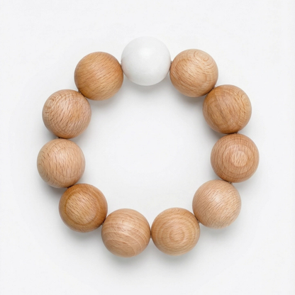 Dessous de plat Nid par Reine Mère en billes de bois de hêtre naturel, format circulaire sur fond blanc épuré.